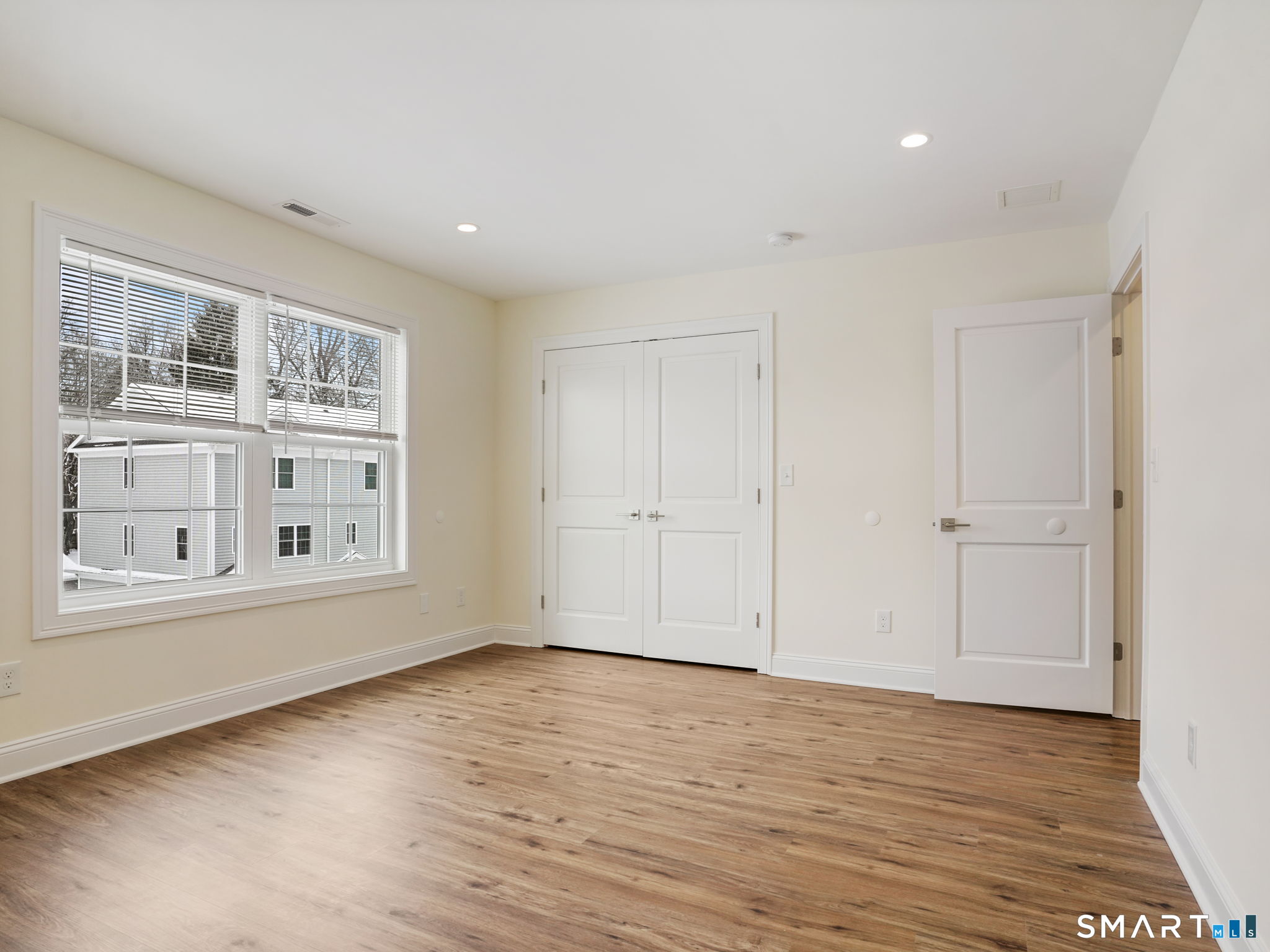 6 Beacon Square, Unit 7 Fairfield, CT 06825 - Photo 25 of 33 a view of an empty room with wooden floor and a window