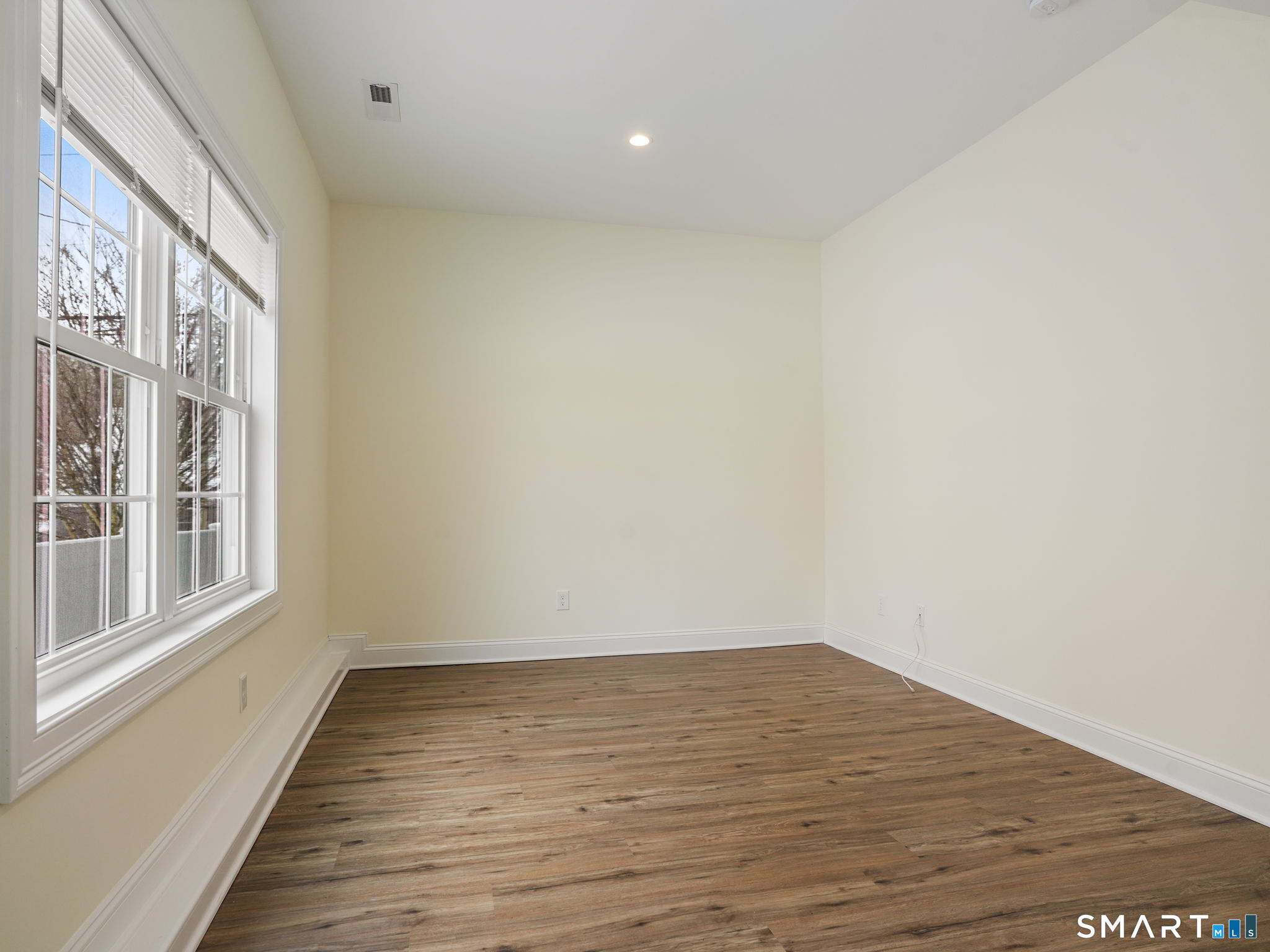 6 Beacon Square, Unit 7 Fairfield, CT 06825 - Photo 29 of 33 a view of an empty room with wooden floor and a window