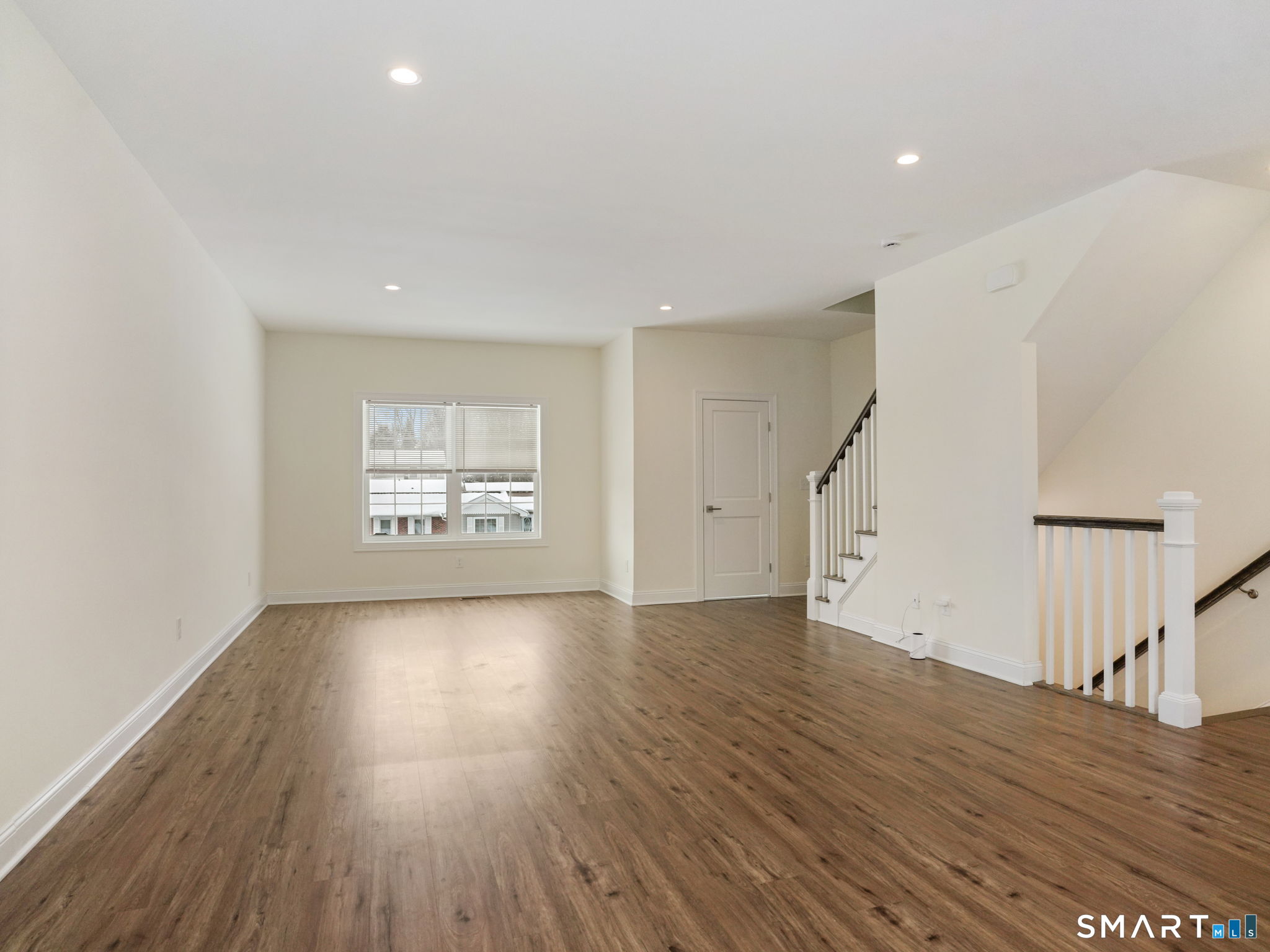 6 Beacon Square, Unit 7 Fairfield, CT 06825 - Photo 3 of 33 a view of an empty room with wooden floor and stairs
