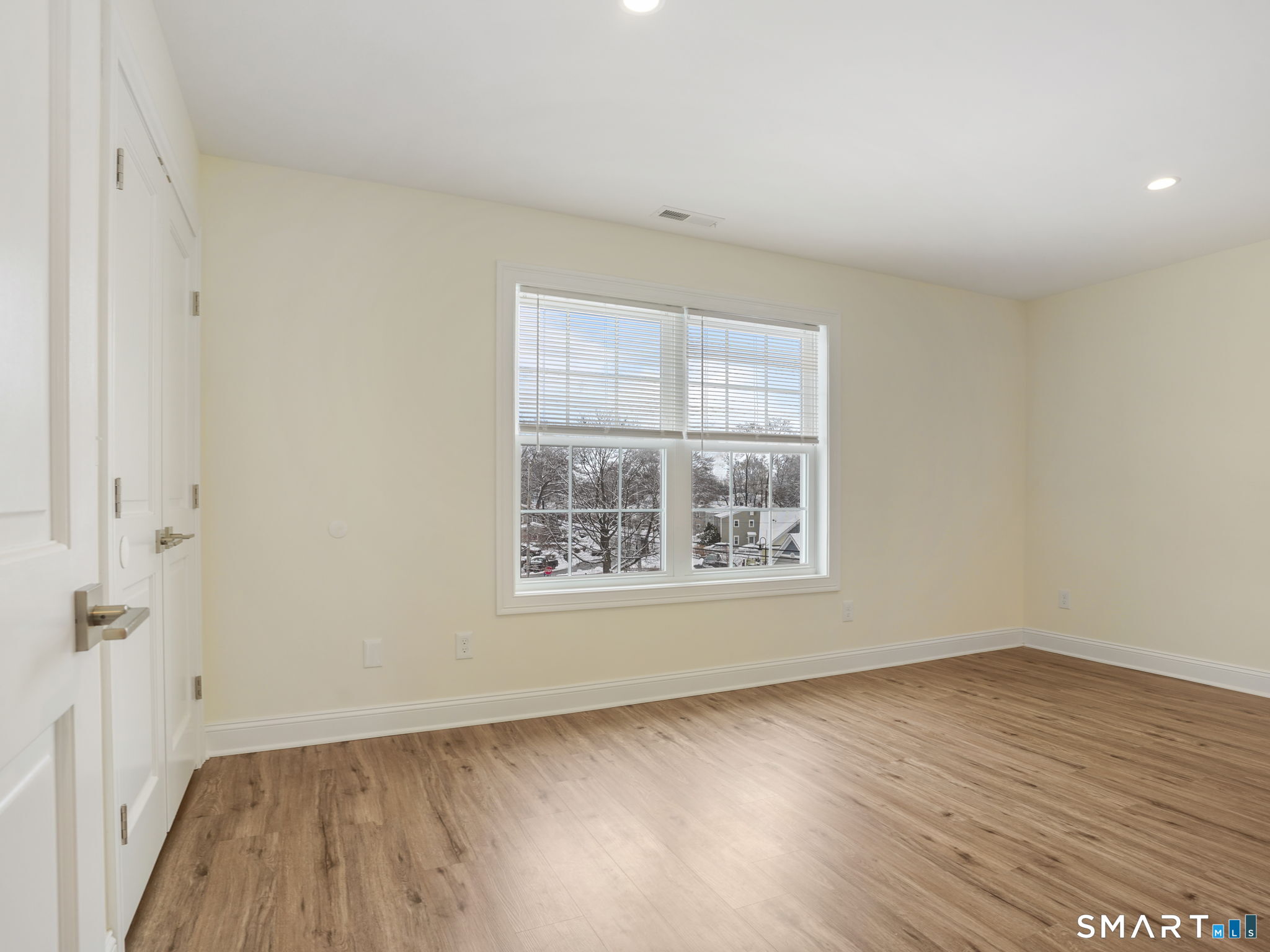 6 Beacon Square, Unit 7 Fairfield, CT 06825 - Photo 5 of 33 an empty room with wooden floor and windows