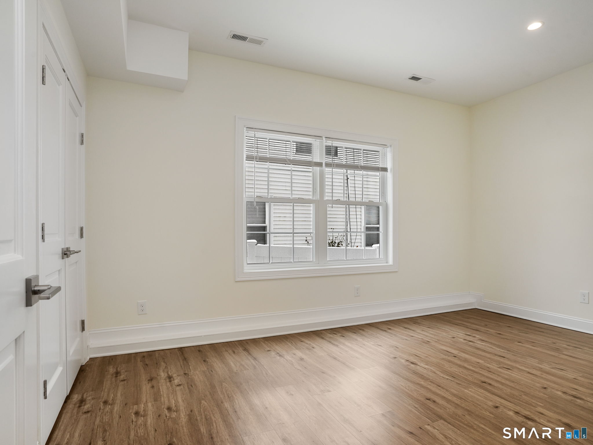 6 Beacon Square, Unit 7 Fairfield, CT 06825 - Photo 7 of 33 an empty room with wooden floor and windows