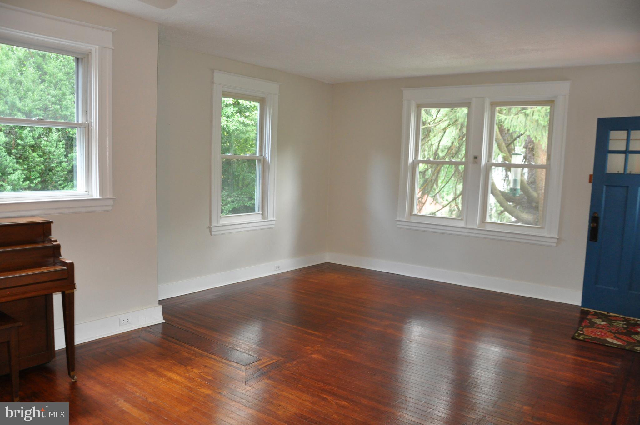 1108 Overbrook Road Baltimore, MD 21239 - Photo 3 of 20 a view of an empty room with wooden floor and a window