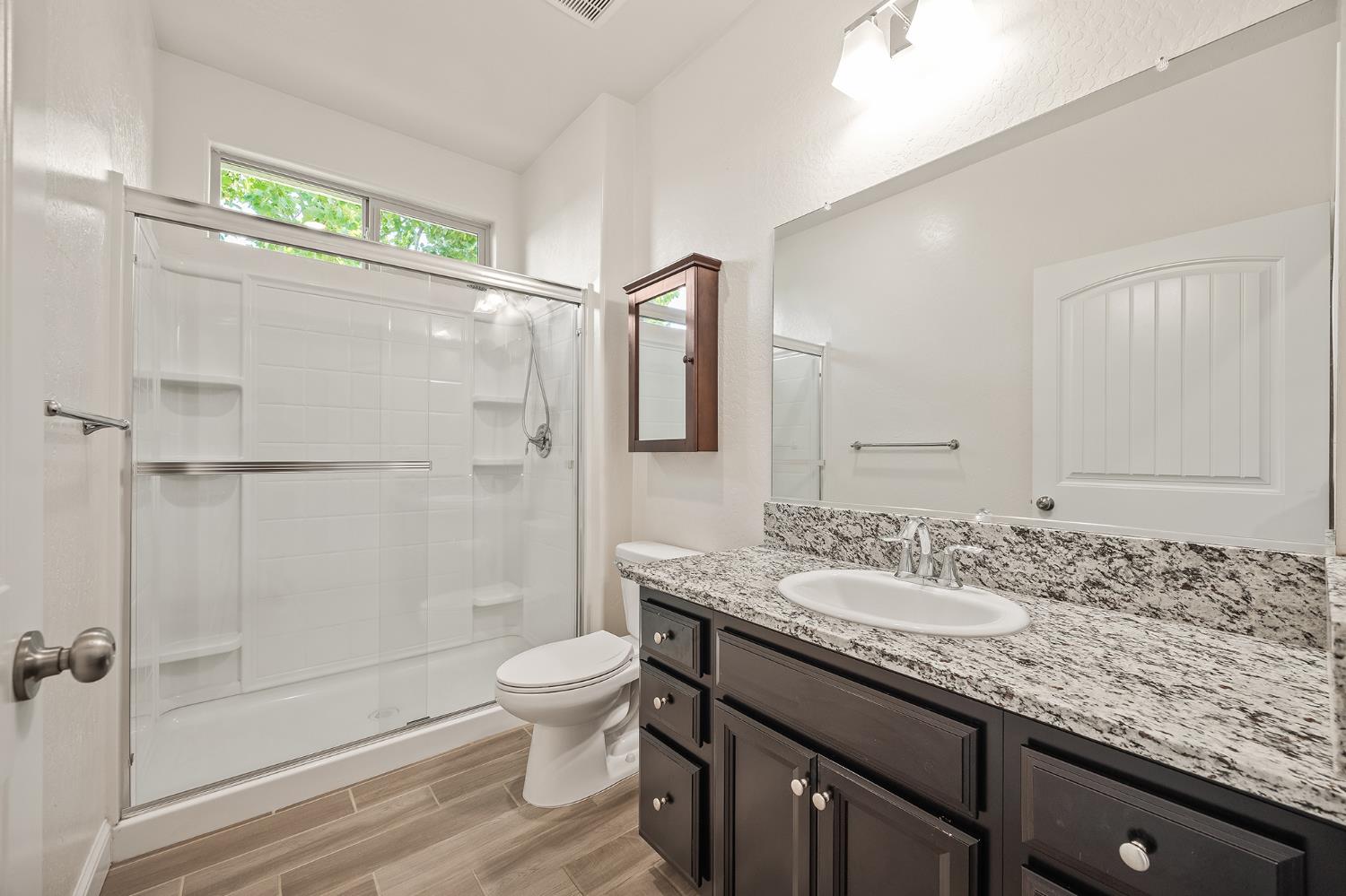 315 Timberline Way Madera, CA 93636 - Photo 14 of 75 a bathroom with a granite countertop sink a toilet and shower