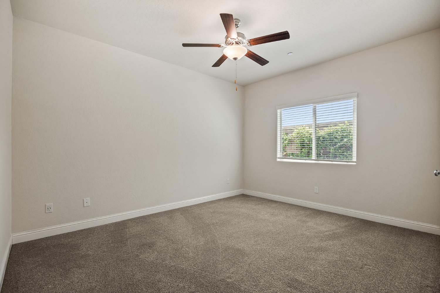 315 Timberline Way Madera, CA 93636 - Photo 17 of 75 an empty room with a window and a fan