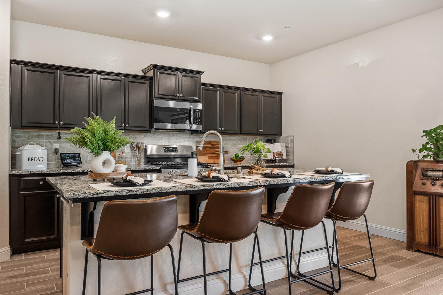 315 Timberline Way Madera, CA 93636 - Photo 30 of 75 a kitchen with granite countertop a counter space chairs stainless steel appliances and cabinets