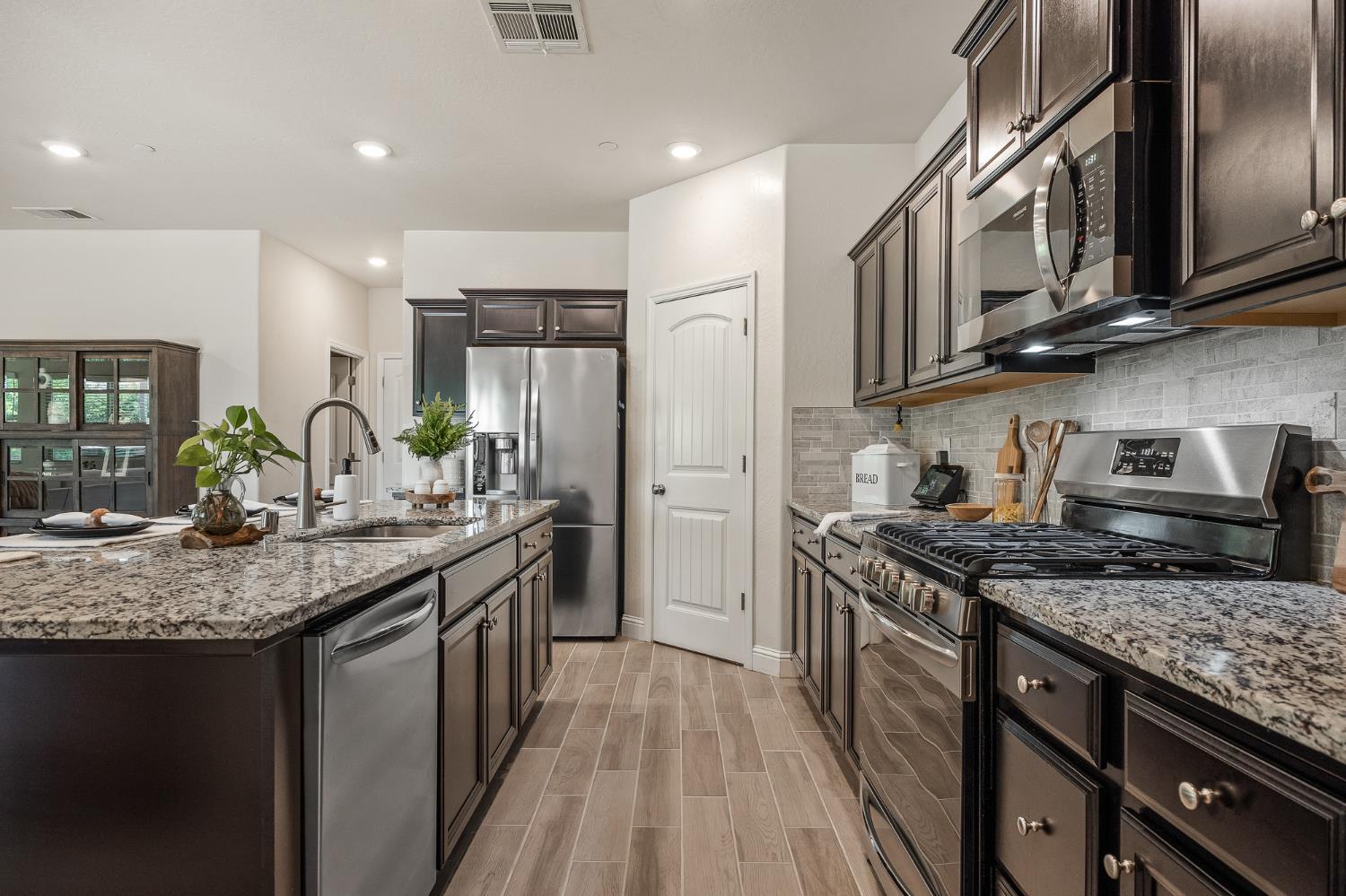 315 Timberline Way Madera, CA 93636 - Photo 32 of 75 a kitchen with stainless steel appliances granite countertop a stove a sink and a refrigerator