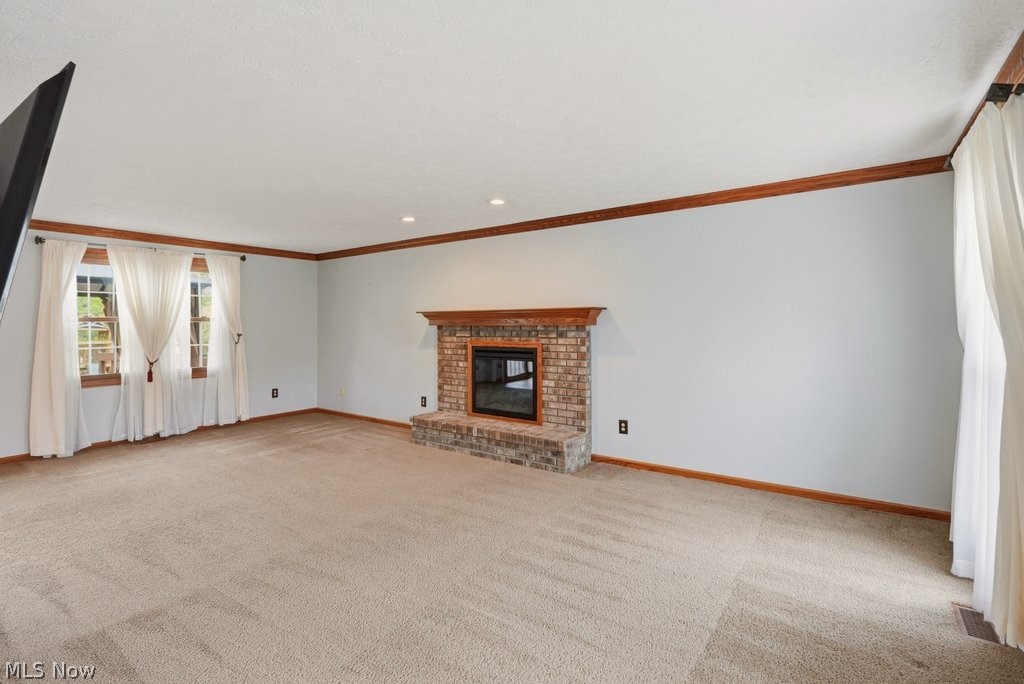 5321 Young Road Stow, OH 44224 - Photo 7 of 37 Spacious interior room featuring a brick fireplace with a wood mantle, recessed lighting, and multiple windows