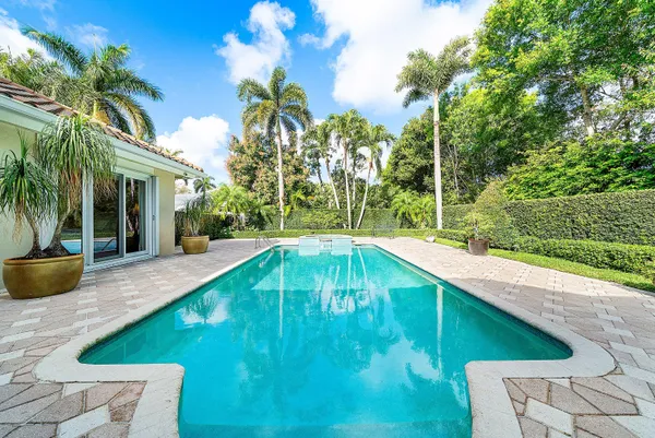 a living room with furniture and a wooden floor next to a window