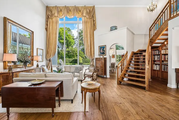a living room with furniture a flat screen tv and a floor to ceiling window
