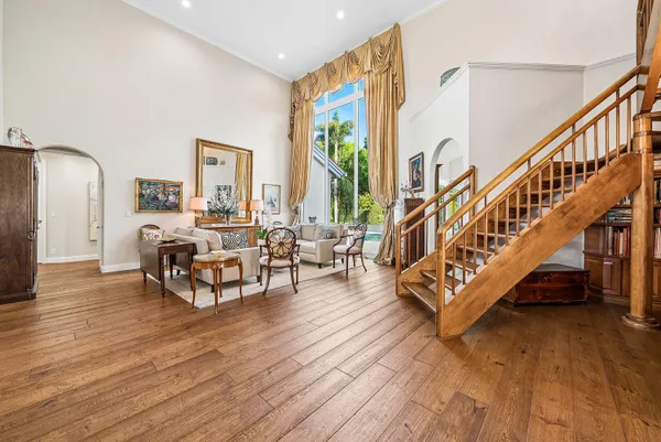 a living room with furniture large window and wooden floor