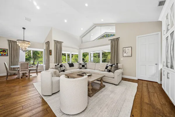 a bathroom with a granite countertop sink a toilet a mirror and a window