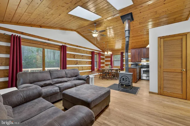 a bedroom with a bed and a large window with wooden floor