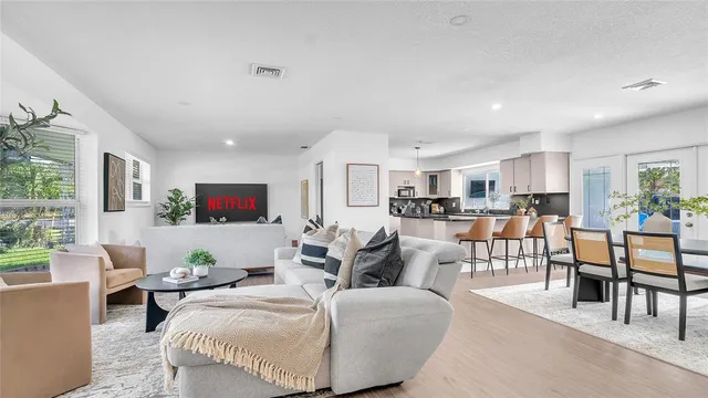 a living room with furniture a dining table and a window
