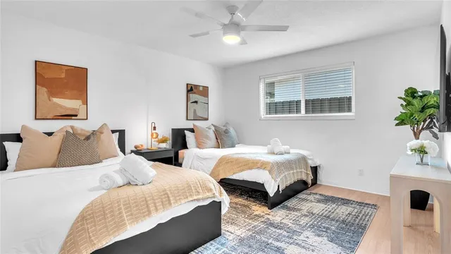 a bedroom with two beds and a potted plant