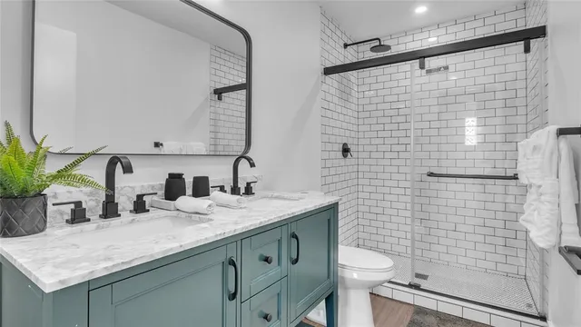 a bathroom with a granite countertop sink a toilet and mirror