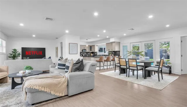 a living room with furniture kitchen view and a flat screen tv