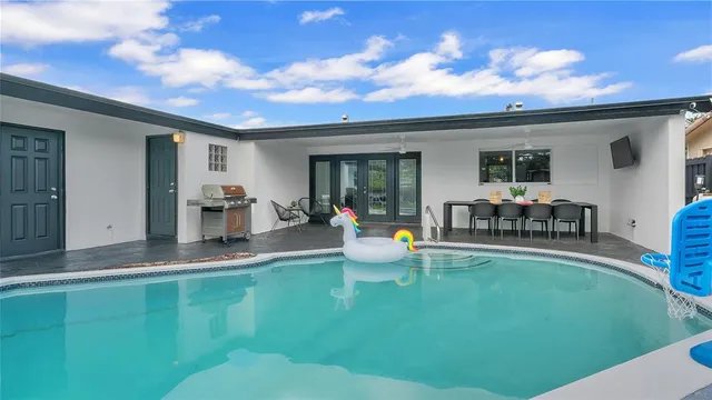 a view of a backyard with table and chairs and potted plants