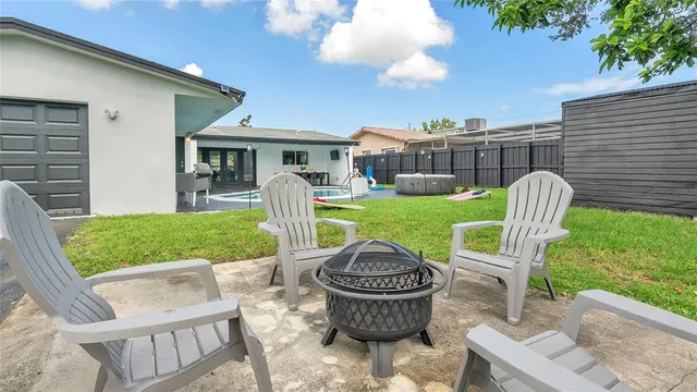a view of a chair and table in backyard of the house