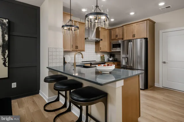 a kitchen with stainless steel appliances granite countertop a sink refrigerator and microwave