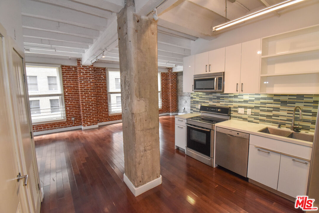 756 South Spring Street, Unit 404 Los Angeles, CA 90014 - Photo 2 of 14 a kitchen with stainless steel appliances a stove sink and refrigerator