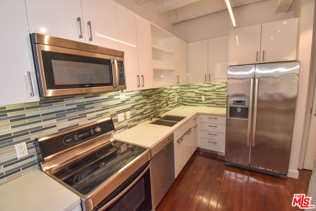 756 South Spring Street, Unit 404 Los Angeles, CA 90014 - Photo 3 of 14 a kitchen with a refrigerator stove and microwave