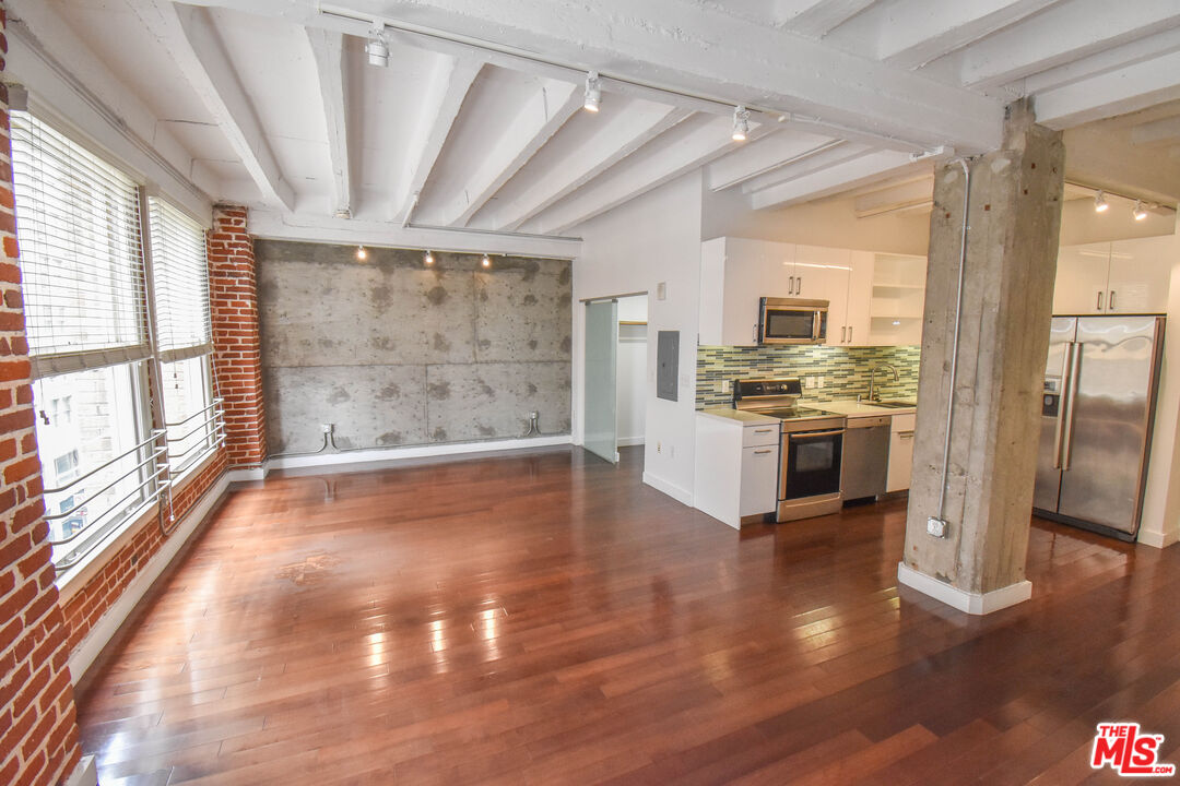 756 South Spring Street, Unit 404 Los Angeles, CA 90014 - Photo 5 of 14 a view of kitchen with stainless steel appliances wooden floor and large window