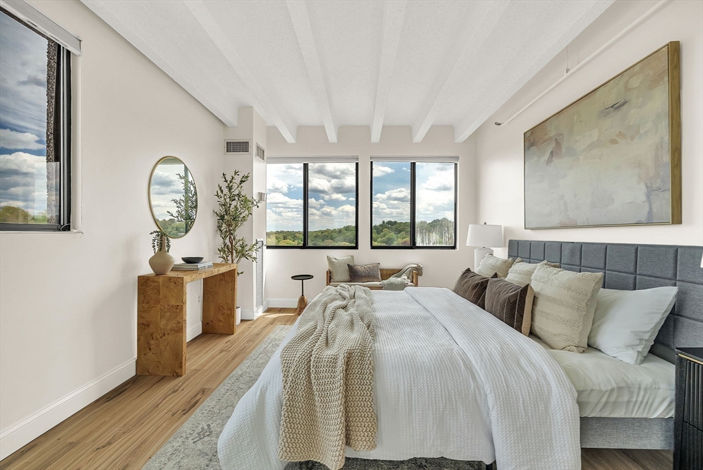 1731 Beacon Street, Unit 1515 Brookline, MA 02445 - Photo 23 of 40 a bedroom with a bed mirror on wall and a large window