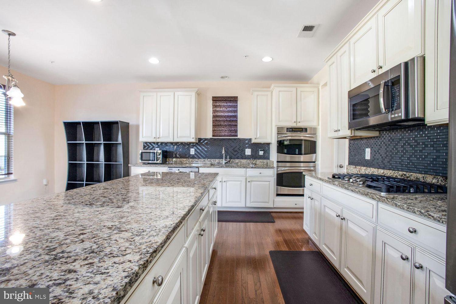 3041 Bel Pre Road Silver Spring, MD 20906 - Photo 13 of 30 a large kitchen with stainless steel appliances granite countertop a stove and a sink