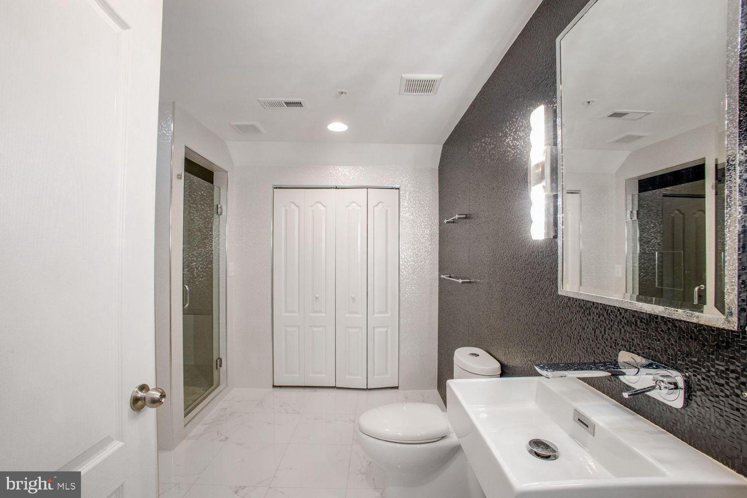 3041 Bel Pre Road Silver Spring, MD 20906 - Photo 29 of 30 a bathroom with a toilet sink and mirror