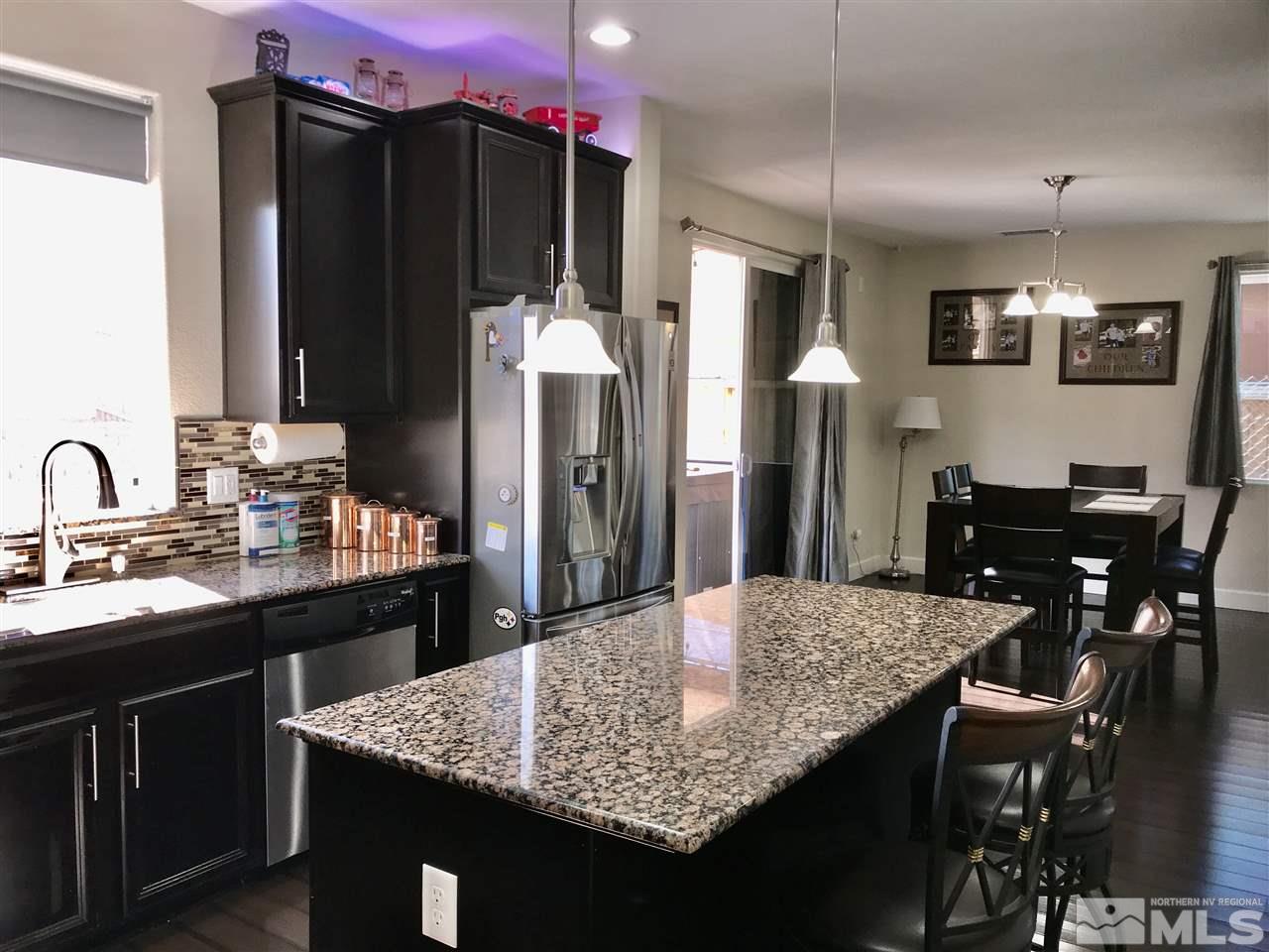 11610 Cervino Drive Reno, NV 89521 - Photo 7 of 20 a kitchen with granite countertop kitchen island stainless steel appliances a sink stove and refrigerator