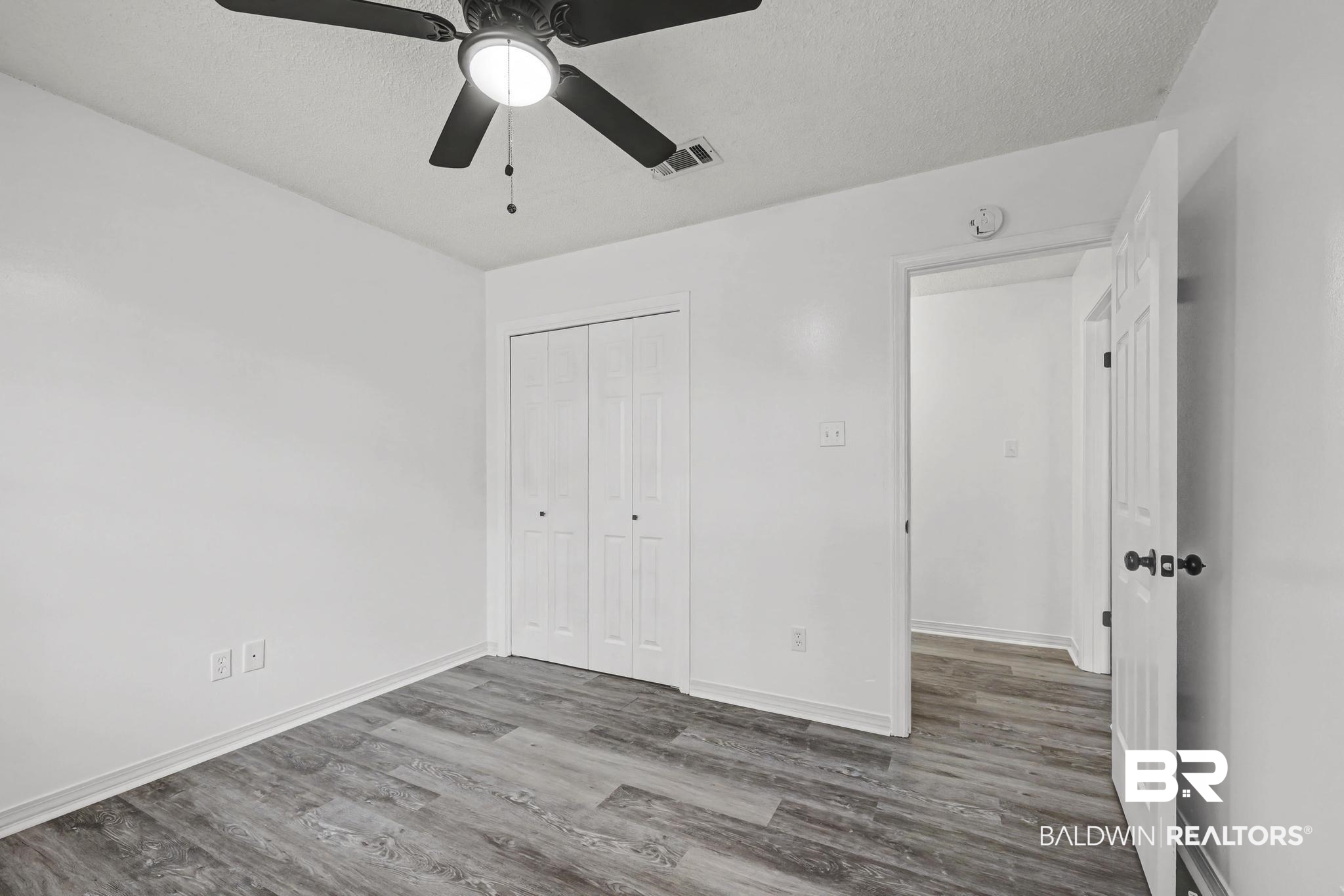 2776 Santa Rosa Circle Lillian, AL 36549 - Photo 23 of 48 Unfurnished bedroom featuring wood finished floors, a textured ceiling, a closet, and ceiling fan