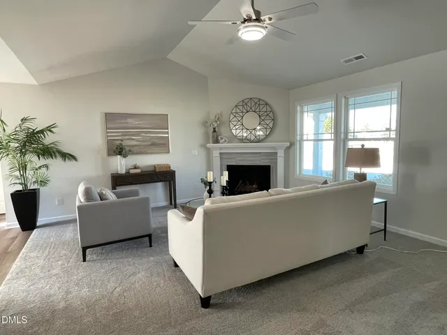 a living room with furniture a fireplace and a large window
