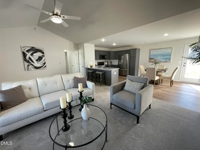 a living room with furniture and kitchen view