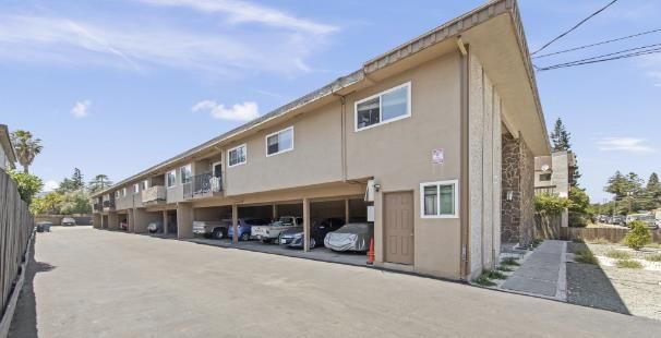 a front view of a building with cars parked