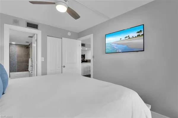 a bedroom with a bed and painting on the wall