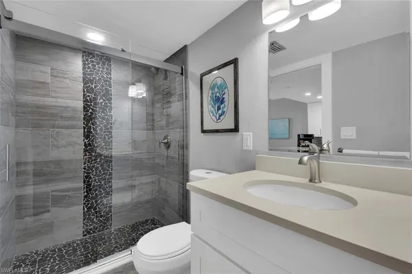 a bathroom with a sink a toilet and shower