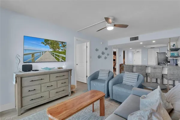 a living room with furniture and paintings on the wall
