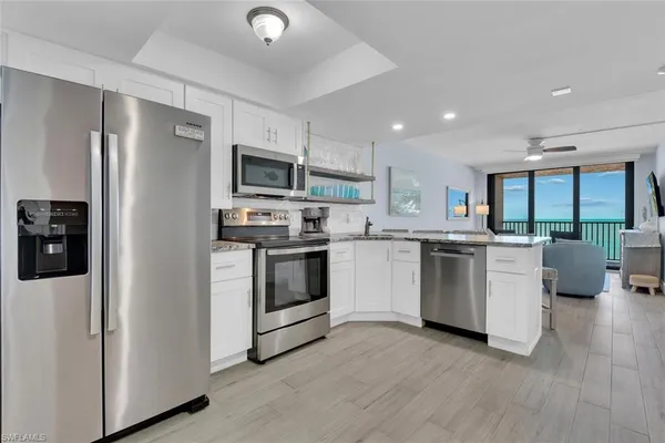 a kitchen with white cabinets and stainless steel appliances