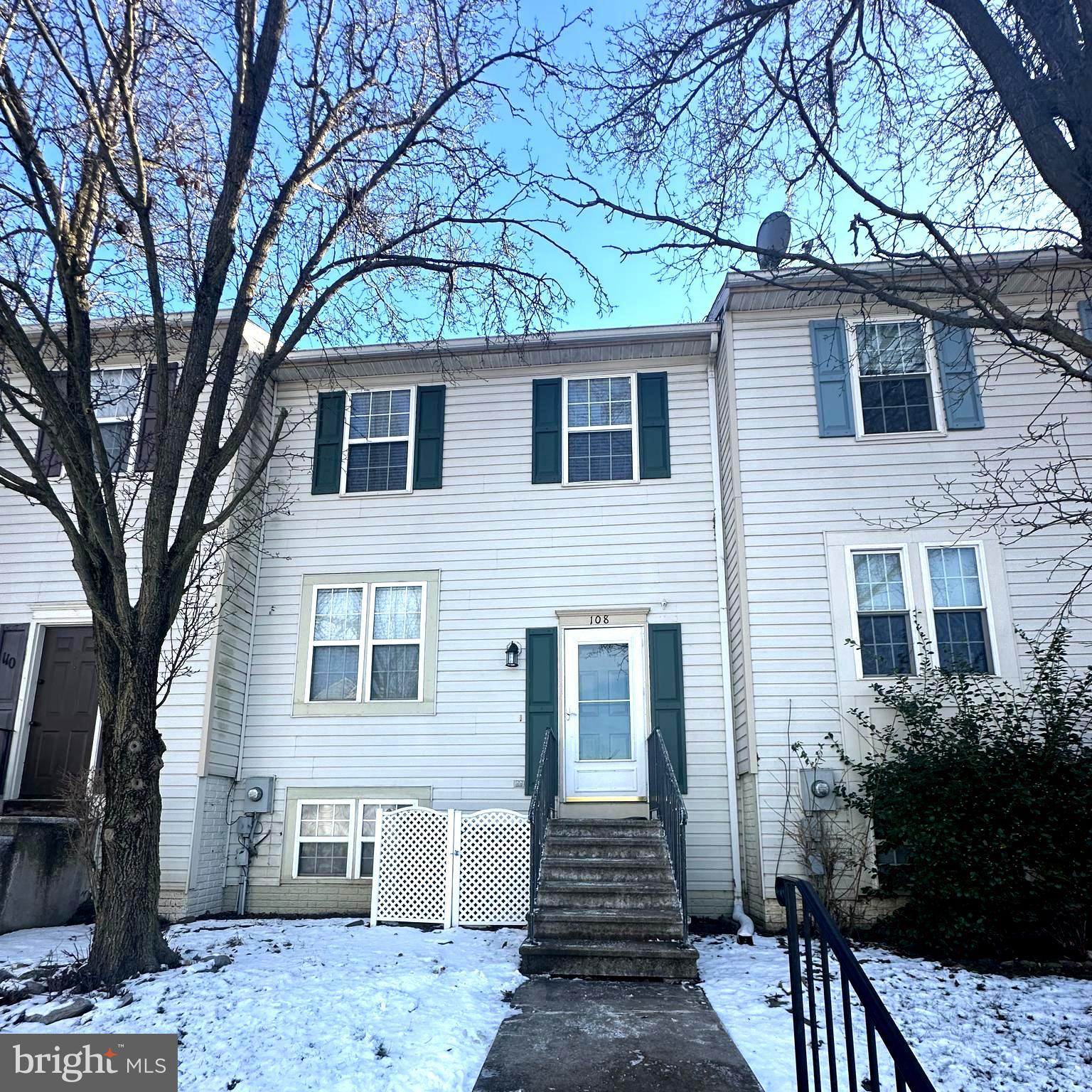 a front view of a house with yard and trees
