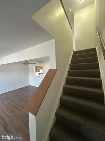 a view of a hallway with bathroom and wooden floor