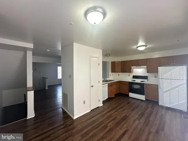 a large kitchen with a lot of counter space and wooden floor