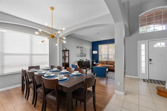 a kitchen with stainless steel appliances granite countertop a stove top oven a sink dishwasher a dining table and chairs with wooden floor