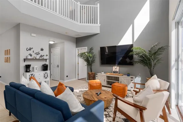 a living room with furniture a rug kitchen view and a chandelier