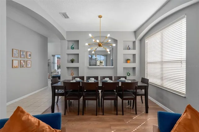 a view of a dining room with furniture and chandelier