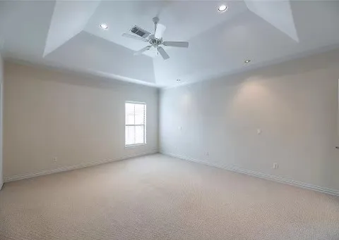 en empty room with windows and chandelier fan