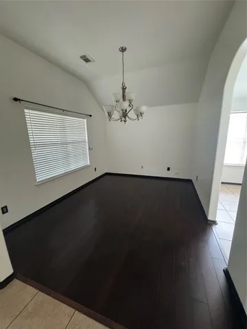 a view of a room with wooden floor a ceiling fan and a window