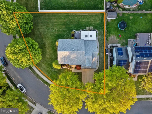 an aerial view of a house with a yard and tennis court