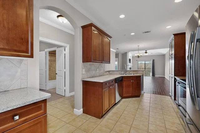 a large kitchen with stainless steel appliances granite countertop a refrigerator and a sink