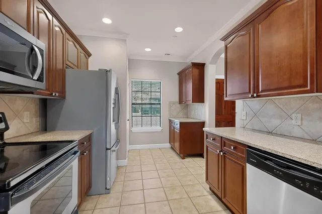a kitchen with stainless steel appliances granite countertop a refrigerator and a stove top oven