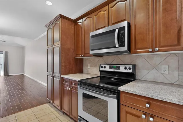 a kitchen with stainless steel appliances granite countertop a stove microwave and refrigerator